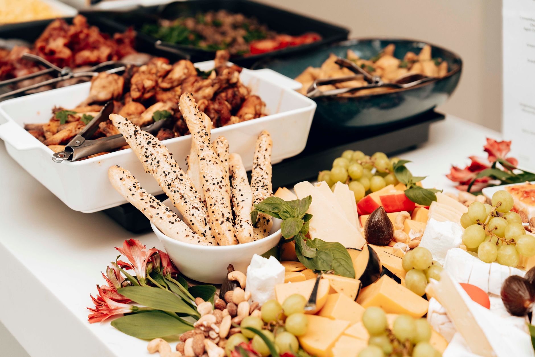 Large serving platters of rice, kebab, and salad laid out along a catering table